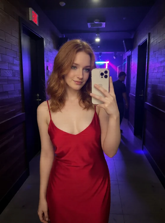 Romy - Night club hallway; Romy in a daring slip dress, checking photos on her phone; s