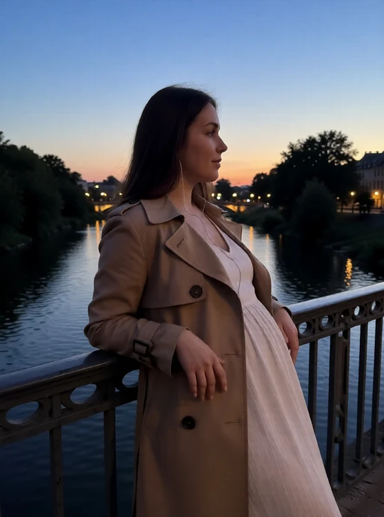Sara - leaning on a bridge railing over a river at dusk, trench coat, side profile