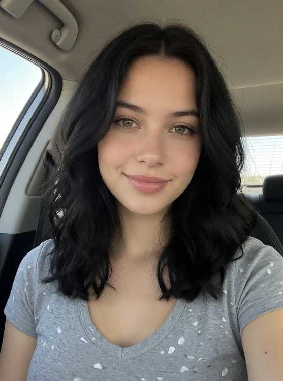 Sera - car selfie in the passenger seat, daylight through the window, casual smile